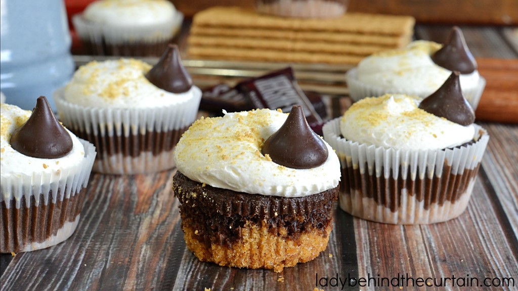 Easy S'more Cupcake Recipe | Bring back childhood memories of sitting around the campfire singing songs and roasting marshmallows with these fun easy to make cupcakes. They are my absolute favorite cupcakes. I love the graham cracker bottom and the marshmallow frosting is simply the best! You don't have to be a professional baker to make something out of this world delicious.